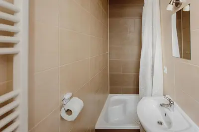 a bathroom with a sink and a toilet and a tub at Hostel Tara in Kraków
