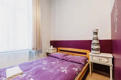 a bedroom with a purple bed and a vase on a table at Hostel Tara in Kraków