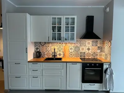 a kitchen with white cabinets and a sink at Pachecos' Garden in Kraków