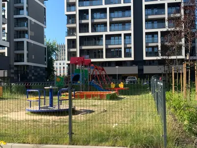 a playground in front of a tall building at Pachecos' Garden in Kraków