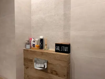 a bathroom with a shelf with toiletries on it at Pachecos' Garden in Kraków