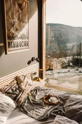 a bed with a plate on top of it next to a window at Drwalówka - Domek 