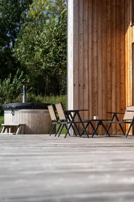 two chairs sitting on a deck with a fire pit at Drwalówka - Domek 