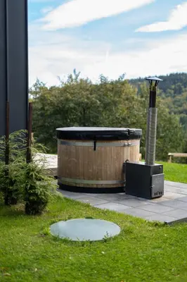 a hot tub sitting on top of a grass field at Drwalówka - Domek 