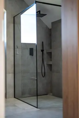 a shower with a glass door in a bathroom at Drwalówka - Domek 