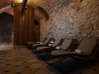 a row of chairs lined up against a brick wall at Hotel Copernicus in Kraków