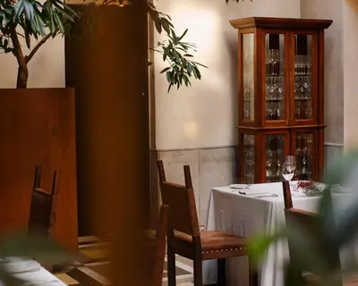a dining room with a table and a cabinet with wine glasses at Hotel Copernicus in Kraków