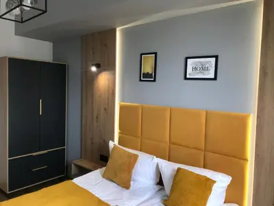a bedroom with a large bed with a wooden headboard at Apartament No82 Yellow Holiday Home Zator in Zator