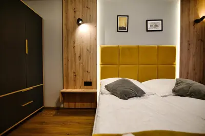 a bedroom with a large bed with a yellow headboard at Apartament No82 Yellow Holiday Home Zator in Zator