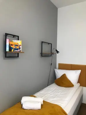 a bedroom with a bed with a tv on the wall at Apartament No82 Yellow Holiday Home Zator in Zator