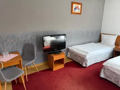 a hotel room with a television and a table and chairs at Przystań nad Sołą in Bielany