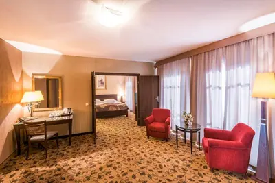 a hotel room with two red chairs and a bed at Great Polonia Kraków Kazimierz in Kraków
