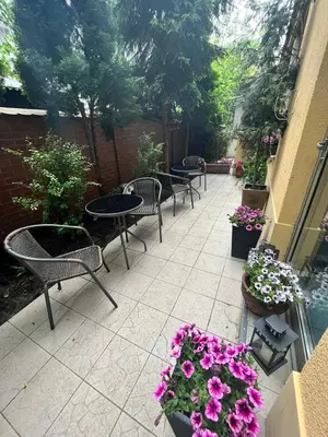 a patio with tables and chairs and purple flowers at Great Polonia Kraków Kazimierz in Kraków