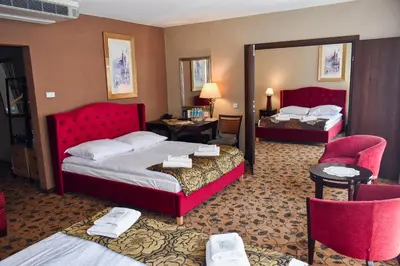 a hotel room with two beds and two chairs at Great Polonia Kraków Kazimierz in Kraków