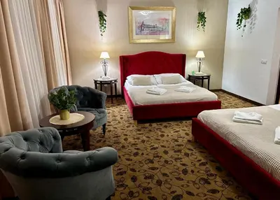 a hotel room with a bed and two chairs at Great Polonia Kraków Kazimierz in Kraków
