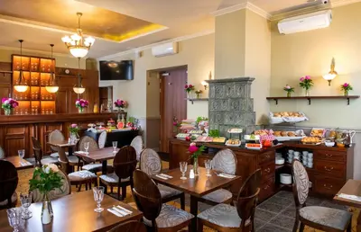 a living room with a table with red flowers on it at Amber Boutique Hotels - Hotel Amber in Kraków