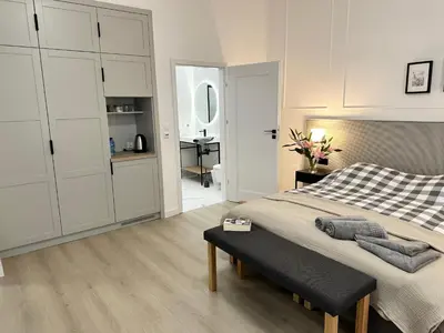 a bedroom with a large bed and a desk at Anny 5 Apartamenty in Kraków