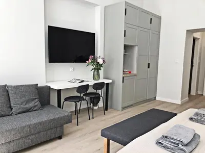 a living room with a couch and a desk with a tv at Anny 5 Apartamenty in Kraków