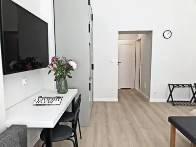 a living room with a table and a vase of flowers at Anny 5 Apartamenty in Kraków