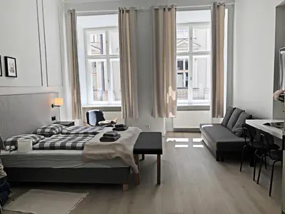 a bedroom with a bed and a couch and windows at Anny 5 Apartamenty in Kraków