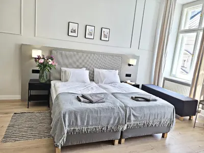 a bedroom with a large bed and a vase of flowers at Anny 5 Apartamenty in Kraków