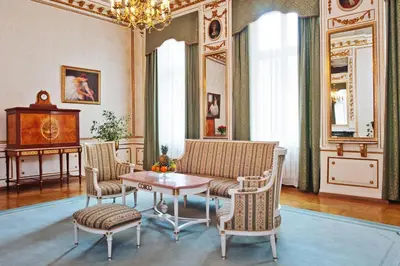 a banquet hall with white tables and chairs and a chandelier at Grand Hotel in Kraków