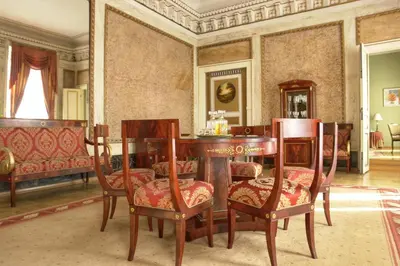 a restaurant with tables and chairs and a chandelier at Grand Hotel in Kraków