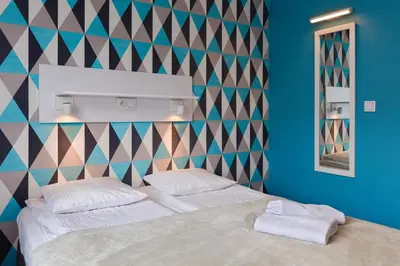 a bedroom with a bed with two towels on it at Premium Hostel in Kraków