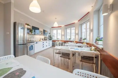 a kitchen and dining room with tables and chairs at Premium Hostel in Kraków