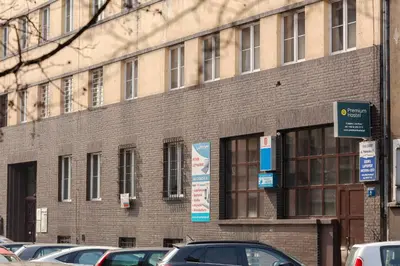 a brick building with cars parked in front of it at Premium Hostel in Kraków