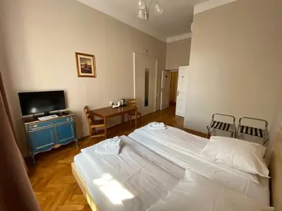 a bedroom with a large white bed and a television at Aparthotel Maria in Kraków