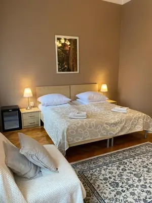 two beds in a room with two tables and two lamps at Aparthotel Maria in Kraków