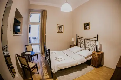 a bedroom with a bed and a table and a chair at Aparthotel Maria in Kraków