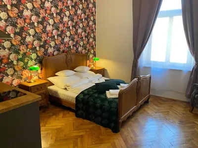 a bedroom with a bed with a floral wall at Aparthotel Maria in Kraków