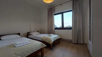 a bedroom with two beds and a large window at Apartamenty Starowiejska 39, Ryczów - 10km od Zator Energylandia in Zator