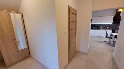 an empty room with a door and a kitchen at Apartamenty Starowiejska 39, Ryczów - 10km od Zator Energylandia in Zator