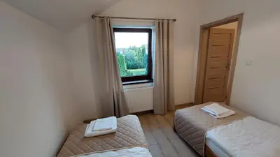 a bedroom with two beds and a window at Apartamenty Starowiejska 39, Ryczów - 10km od Zator Energylandia in Zator