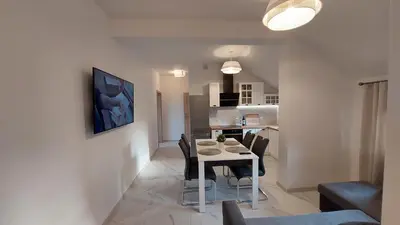 a dining room and kitchen with a table and chairs at Apartamenty Starowiejska 39, Ryczów - 10km od Zator Energylandia in Zator