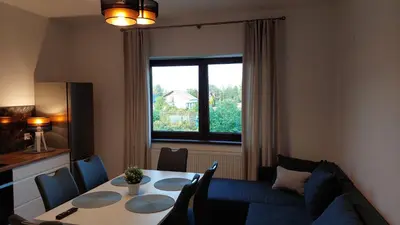 a living room with a table and a blue couch at Apartamenty Starowiejska 39, Ryczów - 10km od Zator Energylandia in Zator