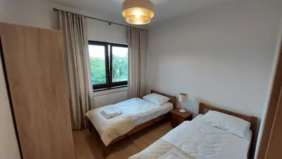 a small room with two beds and a window at Apartamenty Starowiejska 39, Ryczów - 10km od Zator Energylandia in Zator