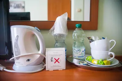a table with a coffee maker and cups on it at Kosmopolita Rooms in Kraków