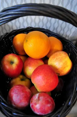 a basket full of apples and oranges and apples at Kosmopolita Rooms in Kraków
