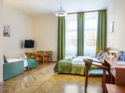a hotel room with two beds and a tv at Kosmopolita Rooms in Kraków