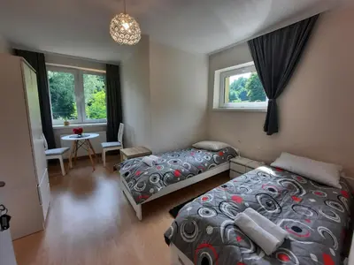 a bedroom with two beds and a table and windows at DOM POD SOKOLICĄ in Będkowice