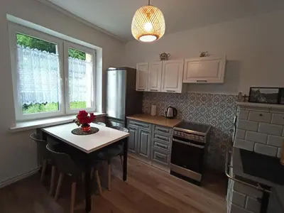 a kitchen with a table and a refrigerator at DOM POD SOKOLICĄ in Będkowice