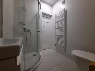 a white bathroom with a shower and a sink at DOM POD SOKOLICĄ in Będkowice