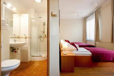 a bathroom with a bed and a toilet and a sink at Mały Kraków Aparthotel in Kraków