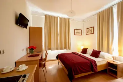 a hotel room with a bed and a desk and a desk at Mały Kraków Aparthotel in Kraków