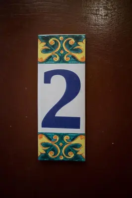 a plaque with the number two on a wall at Home in Krakow Silvio's Apartments in Kraków
