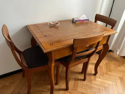 a wooden table with chairs and a book on it at Home in Krakow Silvio's Apartments in Kraków
